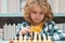Little chess player. Chess school. Child think about chess game. Intelligent, smart and clever school kid pupil. Games