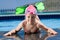 Little child in bathing cap, glasses, fins near sw