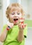 Little child boy brushing his teeth and looking at hourglass