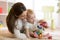 Little child boy and his mommy play with toys at home