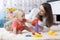 Little child boy and his mommy play with toys at home