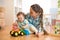 Little child boy and mom play on the floor with tractor toy