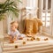 Little child boy plaing with wooden cube blocks on knitted carpet on the floor indoor. Knitted style in the interior: plaid and