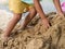 Little child boy playing and climbing sand pile outdoor with dirty foot, hand.