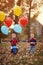 Little child brothers walk in the park with balloons