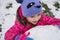 Little child building huge snowball for snowman