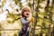 Little child climbing in adventure activity park with helmet and safety equipment. Toddler climbing in a rope playground