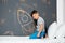 Little child drawing rocket with chalk on wall