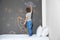 Little child drawing rocket with chalk on wall