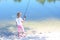 Little child fishing in summer on river on sandy shore