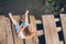 Little child fishing from wooden dock on lake