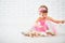 Little child girl dreams of becoming ballerina with ballet shoe