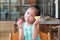 Little child girl eating slice fruits watermelon and pineapple at the restaurant with looking at camera