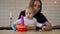 Little child girl and her mommy play with color toys at home