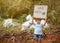 The little child girl holding `Save The Earth` Poster showing a sign protesting against plastic pollution in the forest. The conce