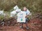 The little child girl holding `Save the plane` Poster showing a sign protesting against plastic pollution in the forest. The conce