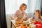 Little child girl learning kneading helping adult mom in kitchen