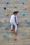 Little child girl trying on free climbing on the playground wooden wall outdoors
