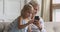 Little child girl using mobile phone with smiling elderly grandmother.