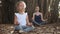 Little child girl with young mother meditating together under banyan tree