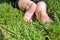 Little child on the grass, baby feet on the green grass in the park