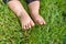 Little child on the grass, baby feet on the green grass in the park