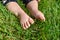 Little child on the grass, baby feet on the green grass in the park