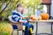 Little child and his father making jack-o-lantern for halloween