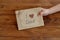 Little child holds a card I love dad. Postcard made of cardboard and wrapping paper, decorated with wooden heart, waxed cord