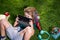 Little child learning outdoor by studying online and working on tablet in green field. Preschool student outdoor.