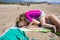 Little child lying on mother over towels at beach