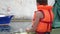 little child in orange life jacket vest preserver on board of pleasure boat during summer vacation travel