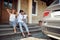 Little child with parents enjoying in front house