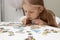 Little child picks up picture from pieces of puzzles