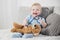 Little child plays doctor with teddy bear at home