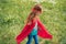 little child in red superhero costume standing