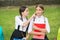 Little child in school uniform touch skin of girl classmate sitting on park bench, skincare