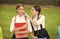 Little child in school uniform touch skin of girl classmate sitting on park bench, skincare