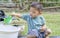 Little child shovels soil into pots to prepare plants for planting. Toddler boy digging soil for planting to Mother\\\'s little