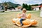 Little child sits on a swing in the playground on the beach. Side view