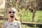 Little child smile on swing in summer yard. Fashion girl in sunglasses enjoy swinging on sunny day. Beauty kid smiling