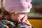 Little child in the street closes his face with the palm of his hand