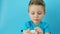 Little child taking pill on blue background. Household danger. Woman health and health care