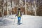 Little child with touring skis in snowy road