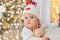 Little child under Christmas tree. baby boy in snowman hat with gifts under Christmas tree with many gift boxes presents