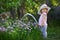 Little child watering onions in the garden