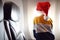 Little child wearing Santa Claus hat traveling by an airplane. Preschooler boy looking at aircraft window during flight. Family