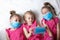 Little children girls in pink dresses in blue medical masks. Global quarantine. Protection against coronavirus, influenza