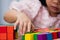 Little children`s hands are having fun arranging colorful wooden blocks. Focus on a specific point