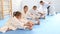 Little children in white kimono doing stretching before karate ore judo training